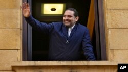 PM Lebanon Saad Hariri melambai kepada pendukungnya dari jendela rumahnya di Beirut, Lebanon, Rabu (22/11). 