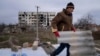 Місцевий житель допомагає сусіду лагодити зруйнований будинок, Архангельське, Херсоншина, 5 грудня 2022. (AP Photo/Evgeniy Maloletka)