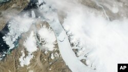 Esta imagen de satélite proporcionada por la NASA muestra el enorme témpano desprendido del glaciar en Groenlandia.