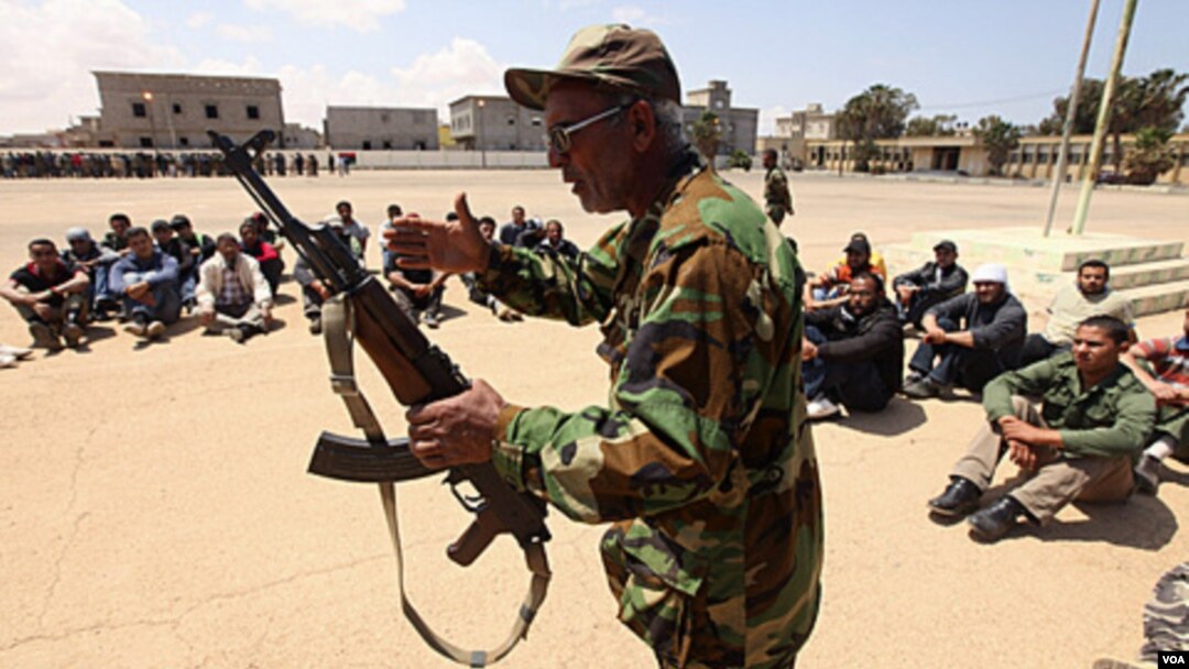 Tentara oposisi pemerintah Libya mengajarkan cara penggunaan senjata pada relawan di Benghazi.