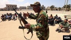 Tentara oposisi pemerintah Libya mengajarkan cara penggunaan senjata pada relawan di Benghazi.