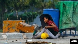 FILE - A protester holds onto the shirt of a fallen demonstrator during a crackdown by security forces on anti-coup protests in Hlaing Tharyar township in Yangon, Myanmar, March 14, 2021.