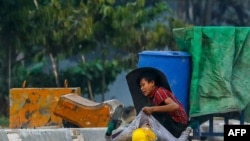 A protester holds onto the shirt of a fallen demonstrator during a crackdown by security forces on anti-coup protests in Hlaing Tharyar township in Yangon, Myanmar.