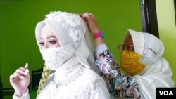 Masker menjadi pernik tambahan yang wajib dalam busana pengantin kala pandemi. (Foto: Nurhadi)