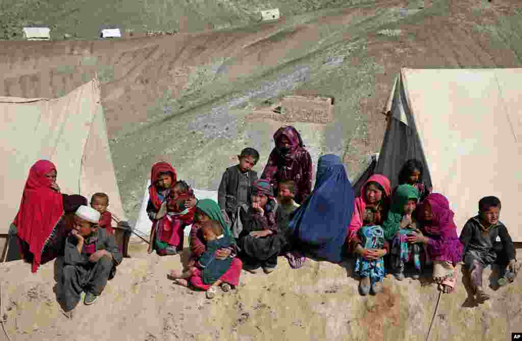 Survivors sit in front of their tents near the site of the landslide that killed hundreds of people. Authorities are trying to help the 700 families displaced by the torrent of mud that swept through their village, in Badakhshan province, northeastern Afghanistan, May 6, 2014.