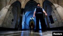  在渥太华国会山庄的国会图书馆入口附近，一名安全警卫在巡逻（2014年10月23日）