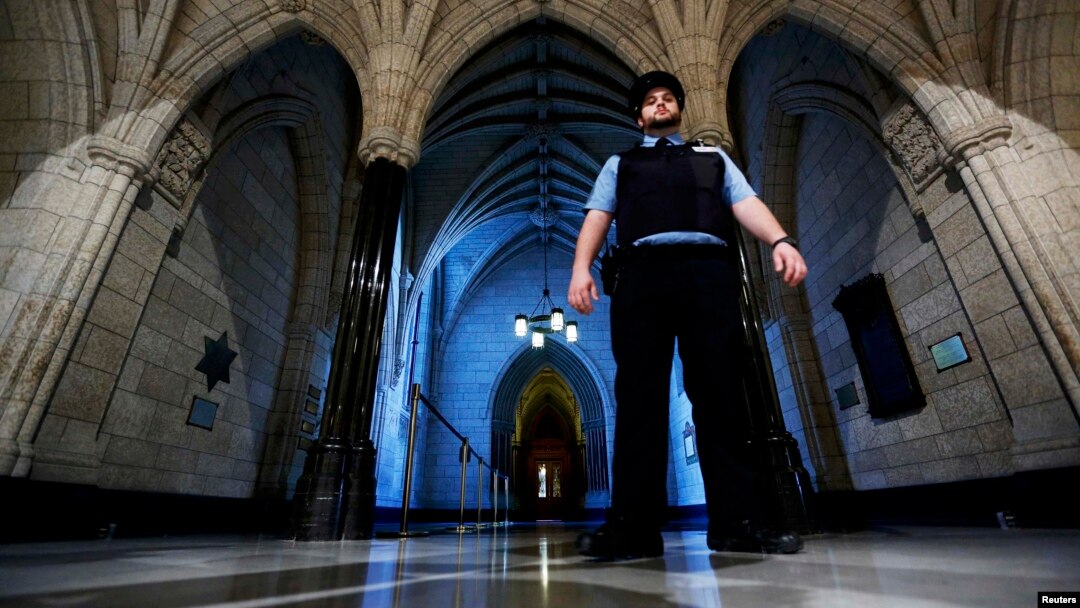 Seorang petugas keamanan berjaga di dekat pintu masuk gedung perpustakan parlemen Kanada di Ottawa, Kamis (23/10).