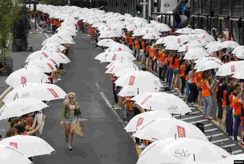 Graduates hold umbrellas during graduation, as part of a mass dance with more than 4,000 graduates dancing in Ljubljana and other Slovenian towns, according to organizers.