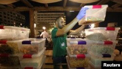 A volunteer holds packaged food from five-star hotels before they are redistributed to the underprivileged families through the initiative, Family Kitchen in Amman, Jordan, June 10, 2018. 