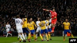 Le gardien italien de la Juventus Gianluigi Buffon, 2e à droite, saute et boxe le ballon lors du match retour de la Ligue des champions contre le Tottenham Hotspur au Wembley Stadium de Londres, le 7 mars 2018.