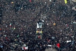 FILE - Coffins of Gen. Qassem Soleimani and others who were killed in Iraq by a U.S. drone strike, are carried on a truck surrounded by mourners during a funeral procession, in the city of Mashhad, Iran, Jan. 5, 2020.