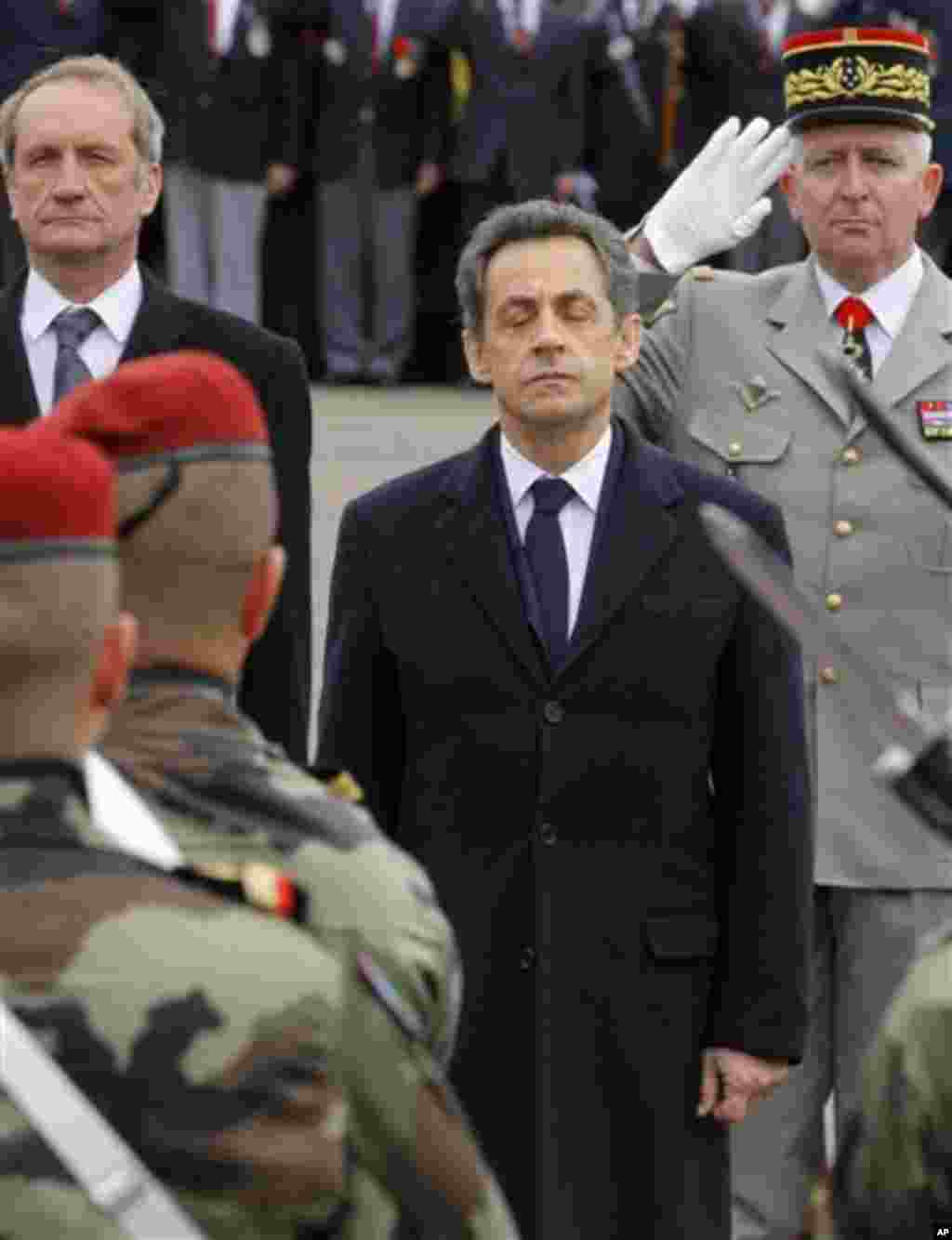 French President Nicolas Sarkozy, center, and Defense Minster Gerard Longuet, left, pay homage to the three soldiers killed by a suspect Interior Ministry official identified as Mohammad Merah, claiming al-Qaida links, and also suspected in the killings 