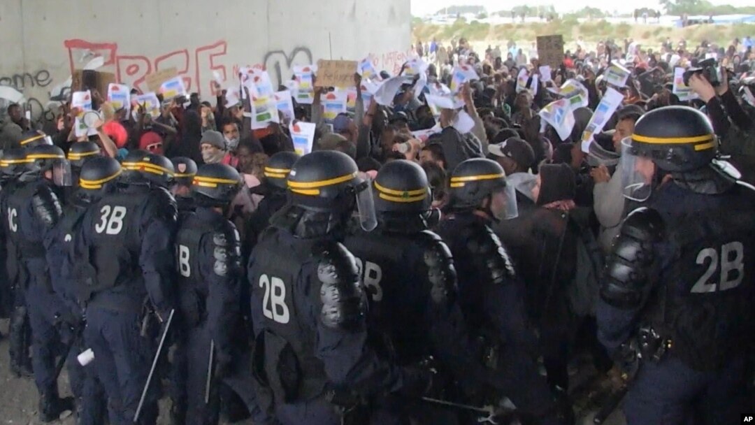 In this grab taken from video, police control protesters, during a demonstration near the migrant camp, in Calais, France, Oct. 1, 2016. 