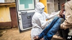 In this Wednesday, Sept. 24, 2014 file photo, health workers load a suspected Ebola patient into the back of an ambulance in Freetown, Sierra Leone. (AP Photo/Michael Duff, File)