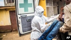 FILE - In this Wednesday, Sept. 24, 2014, photo, health workers lift a suspected Ebola patient into the back of an ambulance in Freetown, Sierra Leone.