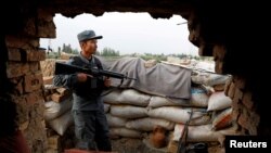 An Afghan policeman keeps watch at the check post on the outskirts of Kabul, Afghanistan July 13, 2021. 