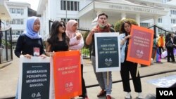 Para peserta aksi Women's March Bandung menyampaikan suaranya di depan gedung DPRD Jawa Barat. Aksi tahun ini fokus menolak eksploitasi anak dan pelecehan seksual. (Foto: Rio Tuasikal/VOA)