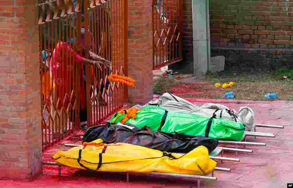A family member throws a garland to pay tribute to relatives who died of COVID-19 at a crematorium near Pashupatinath temple in Kathmandu, Nepal. Doctors in Nepal warned of a crisis as daily coronavirus cases hit a record. 