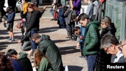 The faithful kneel and pray during Mass in the open air, after Italy's bishops ordered Masses not be held in churches in order to contain the coronavirus outbreak, in Rome, Italy March 8, 2020.