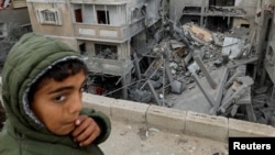 ARCHIVO - Un niño palestino reacciona cerca del lugar de un ataque israelí contra una casa en Rafah, Franja de Gaza, el 24 de marzo de 2024. 