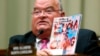 U.S. Representative Billy Long holds up a magazine with an Ebola headline at a House Energy and Commerce Oversight and Investigations Subcommittee hearing.