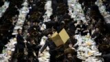 A man distributes fruit from a box at a mass gathering of Satmar Hasidic Jews in New York. The Satmars, a strictly anti-zionist sect of Judaism, gathered to celebrate the 69th anniversary of their founding after Rabbi Joel Teitelbaum&#39;s escape from the holocaust.