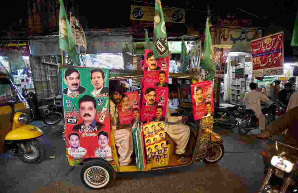 A rickshaw is decorated with campaign posters for candidates in the upcoming election in Rawalpindi, Pakistan, May 8, 2013. 