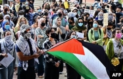 Seorang memegang bendera Palestina ketika para mahasiswa UCLA (University of California, Los Angeles) berpartisipasi dalam "aksi melawan genosida di Palestina" di Bruin Plaza, UCLA di Los Angeles, California (foto: dok).