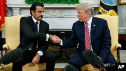 Presiden Donald Trump berjabat tangang dengan Emir Qatar Sheikh Tamim bin Hamad al-Thani di Ruang Oval, Gedung Putih, Washington, 10 April 2018.