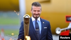 David Beckham saat menyalakan obor olimpiade musim panas di London Inggris Mei tahun 2012 lalu (foto: dok). Kota Sochi, Rusia menjadi tuan rumah olimpiade musim dingin 2014. 