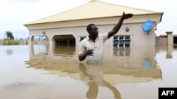 A man gestures next to his flooded house following heavy rain near the Nigerian town of Lokoja, in Kogi State, on Sept. 14, 2018.