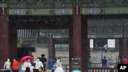 30일 한국 서울 경복궁 방문객들이 마스크를 쓰고 있다.