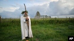 An Archdruid performs a ritual near to the cordoned off Stonehenge as a small group of people gathered to celebrate the Summer Solstice, the longest day of the year, near Salisbury, England, June 21, 2020.