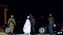 FILE - Former President Yahya Jammeh (C), The Gambia's leader for 22 years, walks towards the plane as he leaves the country on 21 January 2017 in Banjul airport. 