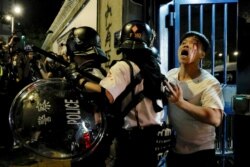 A bleeding man is taken away by policemen after being attacked outside Kwai Chung police station in Hong Kong, July 31, 2019.