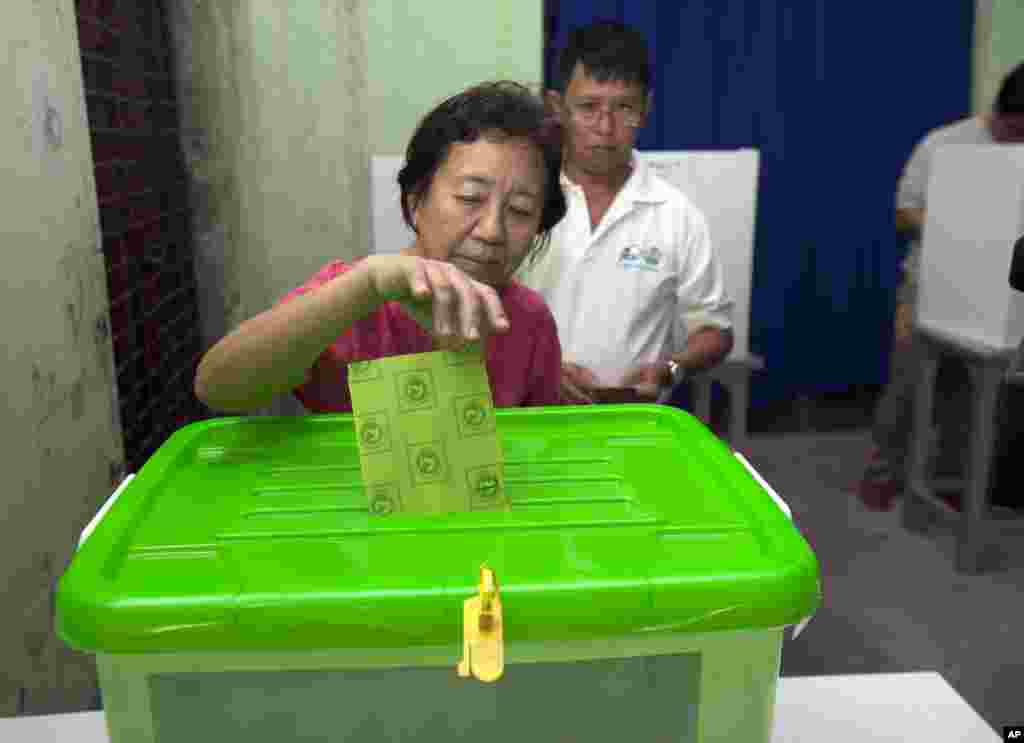 Seorang perempuan memberikan suaranya di TPS dalam pemilu di Yangon, 8 November 2015.