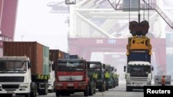 Goods for export are lifted from trucks onto ships in China's port of Qingdao. China wants to be recognized as a market economy by the European Union and U.S. The move would change the way China's export prices are calculated in the WTO making it harder to place punitive tariffs on Chinese products.