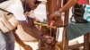 A man washes his hands at a checkpoint in Sierra Leone, as the country enters the third and final day of a three-day countrywide lockdown to combat the Ebola virus in Freetown, March. 29, 2015.