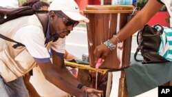 FILE - A man washes his hands at a checkpoint in Sierra Leone, as the country enters the third and final day of a three-day countrywide lockdown to combat the Ebola virus in Freetown, March 29, 2015.