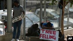 FILE: Workers advertise their skills looking for work outside a hardware store in a Johannesburg suburb, Wednesday, Feb. 26, 2020