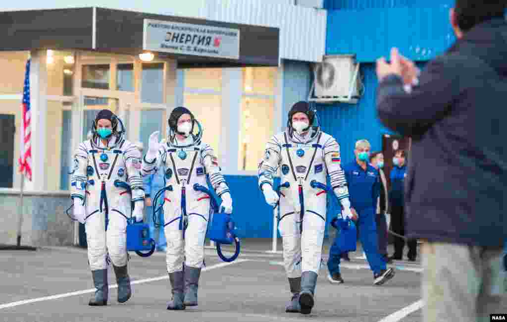 Expedition 64 NASA astronaut Kate Rubins, left, Russian cosmonauts Sergey Ryzhikov, center, and Sergey Kud-Sverchkov, right, leave Building 254 to head to their launch onboard the Soyuz MS-17 spacecraft,&nbsp;at the Baikonur Cosmodrome in Kazakhstan.