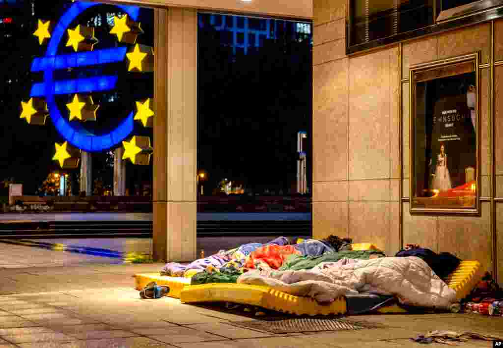 چند بی‌خانمان در کنار ساختمان اپرای جدید در مرکز فرانکفورت، آلمان خوابیده‌اند.