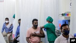 People are administered COVID-19 vaccine in Mumbai, India, April 13, 2021. The country of almost 1.4 billion people is seeing a crippling surge of infections that is threatening to overwhelm hospitals in hard-hit cities.