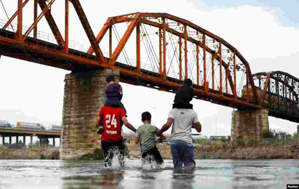 Asylum seekers wait on the banks of the Rio Bravo river after crossing during their journey through Mexico to Eagle Pass, Texas, in Piedras Negras, Mexico, Sept. 26, 2023.