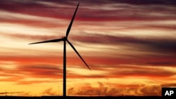 Se observa la salida del sol detrás de un molino de viento antes de la visita del presidente estadounidense Joe Biden a CS Wind, el fabricante de torres eólicas más grande del mundo, el 29 de noviembre de 2023, en Pueblo, Colorado, EEUU.