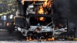 Imodoka yaturiwe n'abari mu myiyerekano kugira bazibire ibarabara, mu gisagara ca Caracas, muri Venezuela