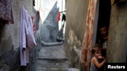 Palestinian children look out of their homes at Al-Shati refugee camp in Gaza City, Sept. 3, 2018.