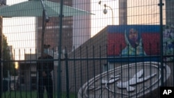 A security guard stands guard behind fences around the U.S. embassy in Beijing on Sept. 6, 2021. The Chinese government says at least 500 Chinese students have been rejected under a policy issued last year by then U.S. President Donald Trump that is…