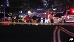 Autoridades trabajando en el lugar de un tiroteo masivo, el domingo 4 de agosto de 2019 en Dayton, Ohio. (AP Foto/John Minchillo)