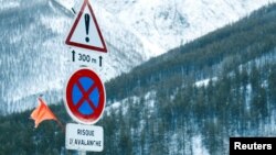 Road signs are pictured on a snow-covered road in Saint-Pancrace as winter weather bringing snow and freezing temperatures continues in France, March 2, 2018. The sign reads, "Avalanche risk." 